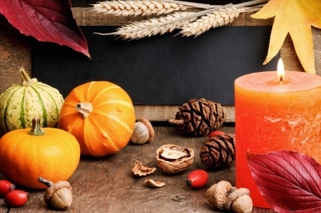 Autumn frame with pumpkins and candle on wooden tableの写真素材
