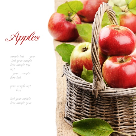 Fresh organic apples in wicker basket isolated over whiteの写真素材