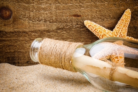 Message in the bottle on rough wood backgroundの写真素材