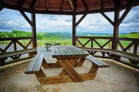 Wooden picnic place with green valley backgroundの写真素材