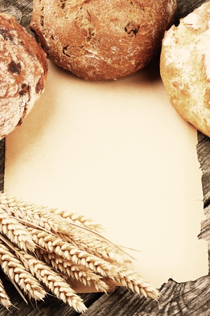 Frame with bread and vintage paper on wooden backgroundの写真素材