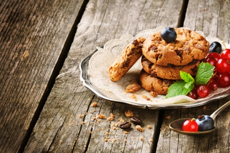 Chocolate chip cookies and berries on wooden tableの写真素材