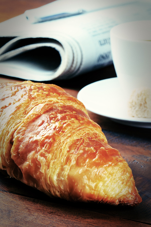Breakfast with fresh croissant and coffee on wooden tableの写真素材