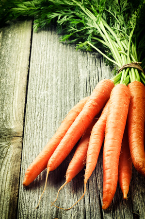 Fresh organic carrots on wooden tableの写真素材