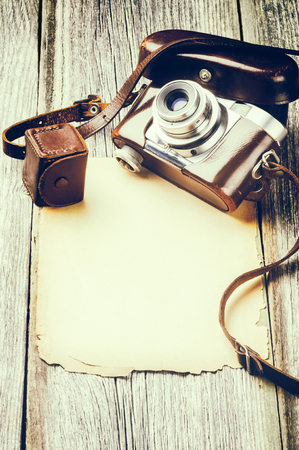 Retro camera on old wood background with vintage paperの写真素材