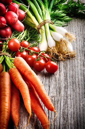Fresh organic vegetables on old wooden tableの写真素材