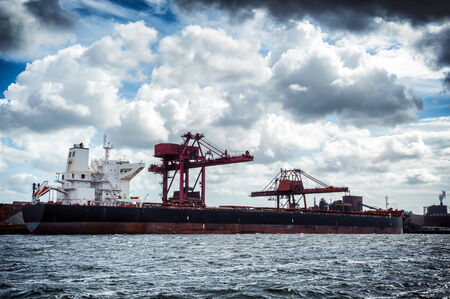 Cargo ship in harbor at cloudy weatherの写真素材