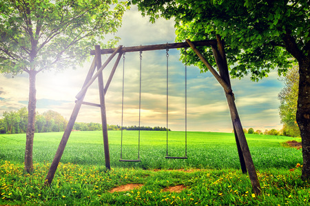 Lonely countryside swing at summer sunsetの写真素材