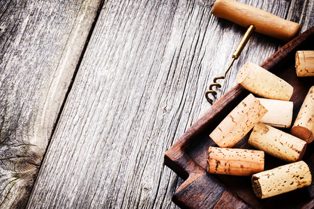 Wine corks and corkscrew on wooden tableの写真素材