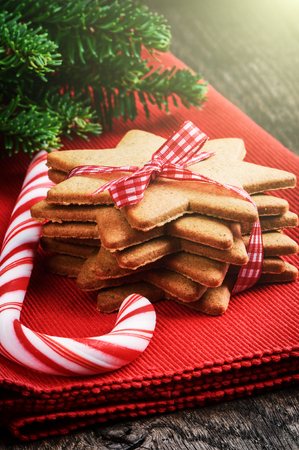 Christmas gingerbread cookies and candy cane on red napkinの写真素材