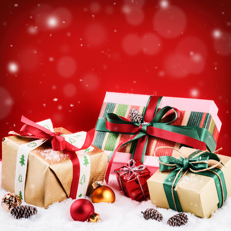 Christmas setting with colorful presents over red backgroundの写真素材