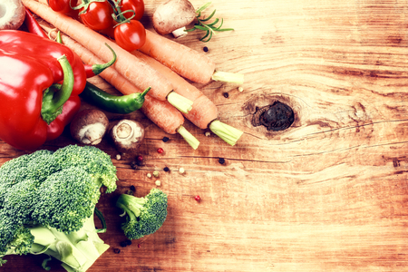 Cooking setting with fresh organic vegetables on old wood background. Healthy eating concept with copy spaceの写真素材