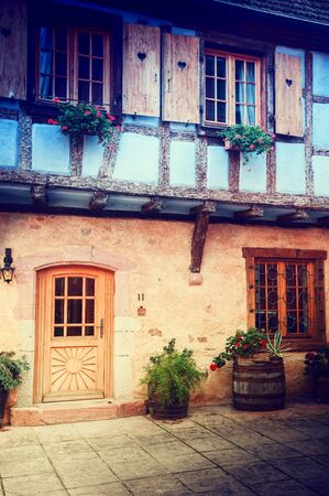 Cozy rustic backyard of traditional timber frame house decorated with flowers. Alsace, Franceの写真素材