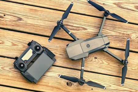 Drone quadcopter with a flight controller over wooden background. Top view, flat layの写真素材