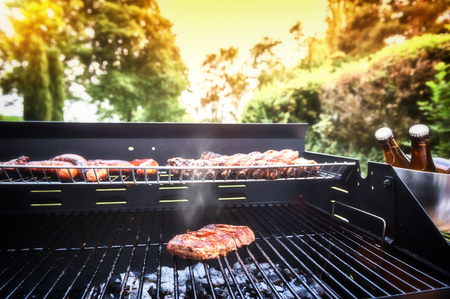 Meat steak cooking on barbecue grill for summer outdoor party. Food background with barbecue partyの写真素材