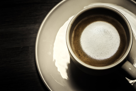 Top view of hot coffee cup on dark background. Food and drink background with copyspaceの写真素材