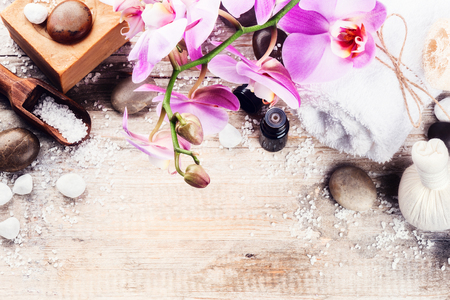 Spa setting with pink orchid, natural soap, herbal massage ball and essential oil. Wellness conceptの写真素材