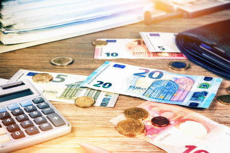 Euro banknotes and coins with bills to pay. Finances and budget conceptの写真素材