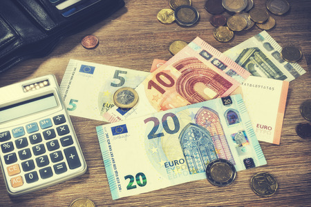 Euro banknotes and coins with bills to pay. Finances and budget conceptの写真素材