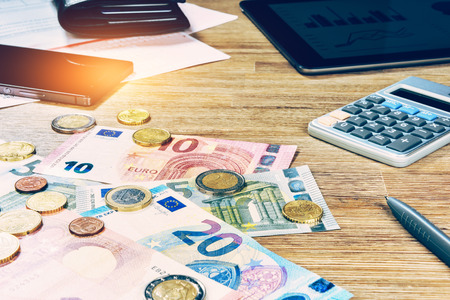 Euro banknotes and coins with bills to pay. Finances and budget conceptの写真素材
