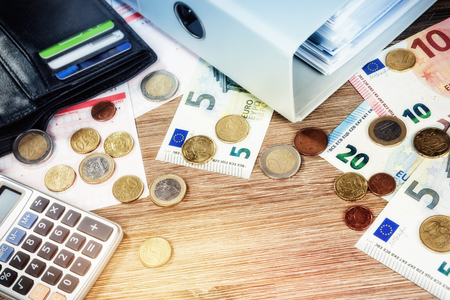 Euro banknotes and coins with bills to pay. Finances and budget concept, copyspaceの写真素材
