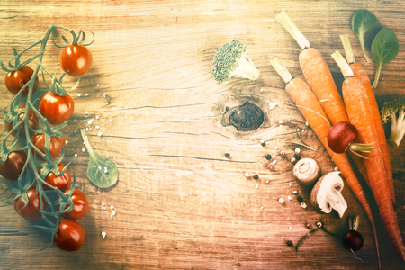 Cooking setting with fresh organic vegetables on old wood background. Healthy eating concept with copy spaceの写真素材