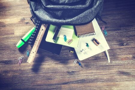 Backpack with school supplies, top view. Back to school concept with copy space