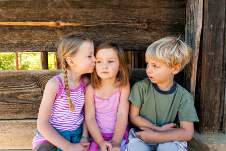 Young girl kissing her friendの写真素材