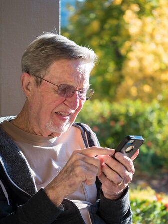 Elderly male using cell phoneの写真素材
