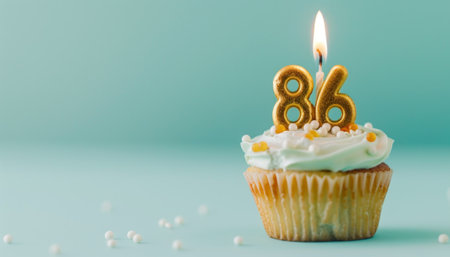 Birthday cupcake with number eighty-six candle on blue backgroundの素材