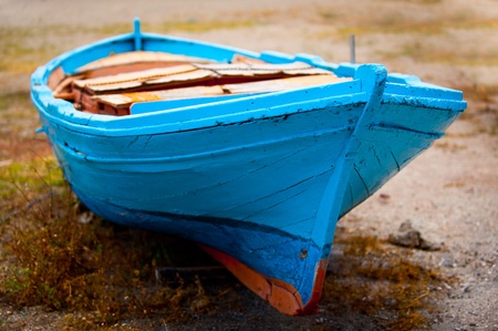 Old blue wooden boat on the grassy beach of Giardini Naxos, Sicily, Italyの写真素材