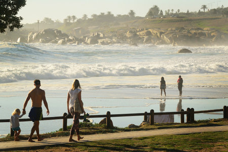 Camps Bay, Cape Town, South Africa - April 30th 2018: A family take a relaxing stroll along the seafront at Camps Bay, Cape Town, South Africaのeditorial素材