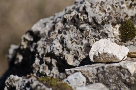 close-up of rock texture, with a small white stone in front