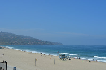 Enjoying a Sunny Beach Day at the Coastline With Gentle Waves and Clear Skiesの写真素材