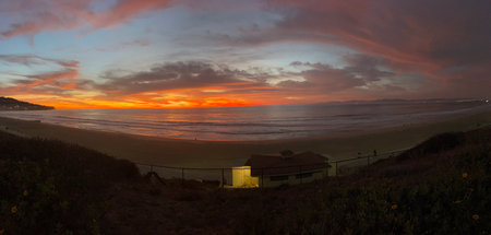 Sunset Paints the Sky With Vibrant Colors Over a Peaceful Beach in Californiaの写真素材