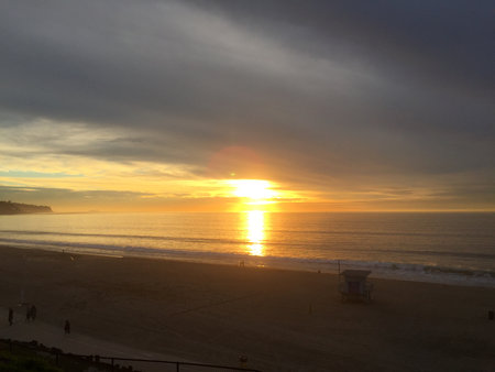 Serene Sunset Casts Golden Hues Over Peaceful Beach and Gentle Waves at Twilightの写真素材