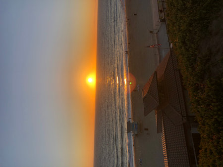 Sunset Over the Beach Creates a Colorful Horizon and Reflections on the Water at Duskの写真素材