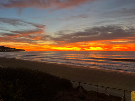 Stunning Sunset Over the Ocean, Casting Vibrant Colors Across the Sky and Reflecting on the Water's Surfaceの写真素材