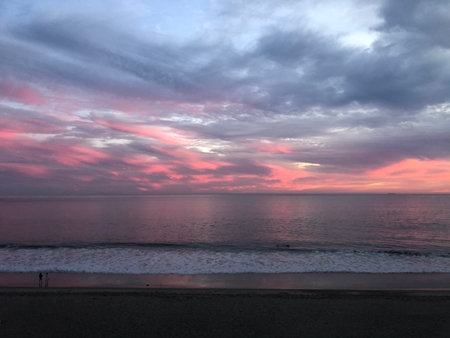 Colorful Sunset Over the Ocean Creates a Serene Atmosphere for Evening Wanderers by the Shoreの写真素材
