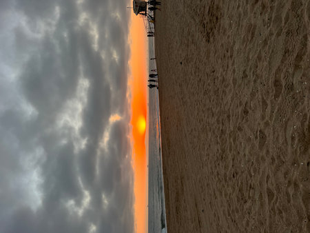 Stunning Sunset Over the Beach With Silhouettes of People Enjoying the Eveningの写真素材