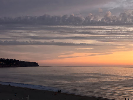 Magical Sunset Paints the Sky With Colors Over Calm Ocean Waves Near a Serene Coastal Landscapeの写真素材