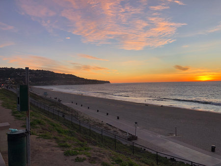 Beautiful Sunset Over Tranquil Beach at Evening, Showcasing Vibrant Colors and Peaceful Wavesの写真素材