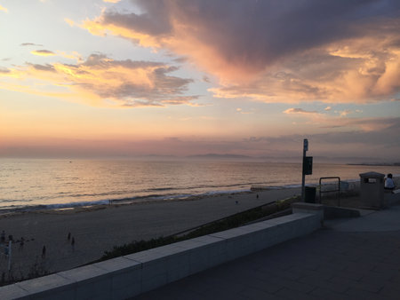 Golden Sunset Paints the Sky Over a Tranquil Beach, Creating a Serene Evening Scene by the Oceanの写真素材
