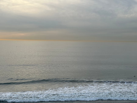 Calm Sunset Over the Tranquil Ocean With Gentle Waves and a Serene Sky Filled With Soft Cloudsの写真素材