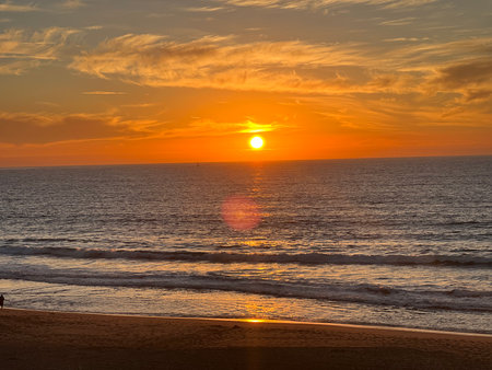Sunset Over the Ocean Reflects Warmth and Tranquility Along the Sandy Beach During a Peaceful Evening Strollの写真素材
