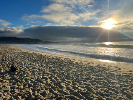 Golden Sunrise Over Tranquil Beach Reveals Gentle Waves and Soft Sands at Dawnの写真素材