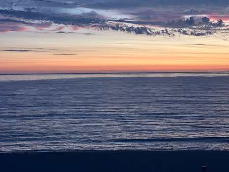 Magnificent Sunset Over the Calm Ocean, Painting the Sky in Hues of Orange and Pinkの写真素材