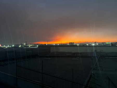 Vibrant Sunset Over City Skyline as Night Begins to Fall on an Industrial Landscapeの写真素材