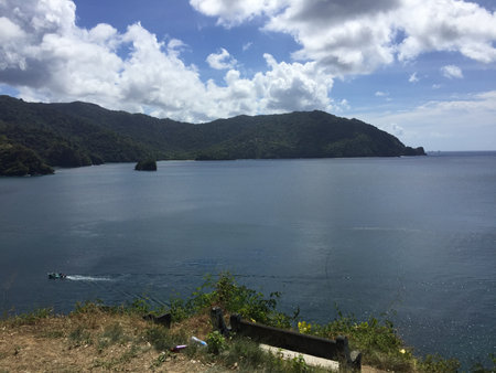 Beautiful Coastal Scene With Rugged Mountains and a Peaceful Ocean Under a Blue Skyの写真素材