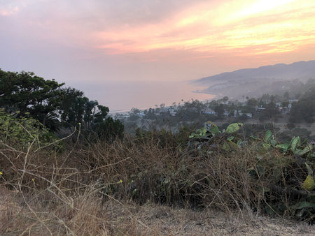 Vibrant Sunset Over the Coastal Hills Showcasing Natureâs Beauty and Serene Atmosphereの写真素材